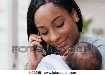Mother on cellphone with her baby View Large Photo Image Stock Image - Mother on cellphone with her baby. Fotosearch