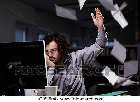 Office worker working late, throwing paper in the air View Large Photo Image Stock Photo - Office worker working late, throwing paper in the air. Fotosearch