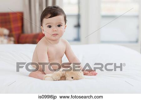 Portrait of a baby boy sitting on bed View Large Photo Image Stock Photography - Portrait of a baby boy sitting on bed. Fotosearch