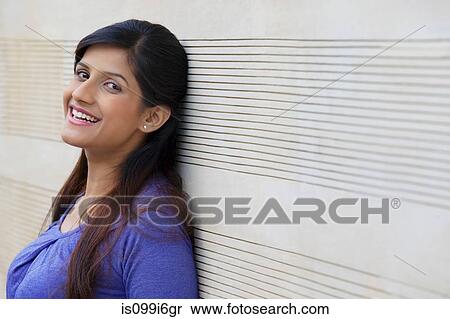 Portrait of a woman leaning against a wall View Large Photo Image Stock Photography - Portrait of a woman leaning against a wall. Fotosearch