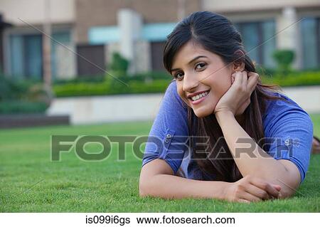 Portrait of a woman lying on a lawn View Large Photo Image Stock Photograph - Portrait of a woman lying on a lawn. Fotosearch