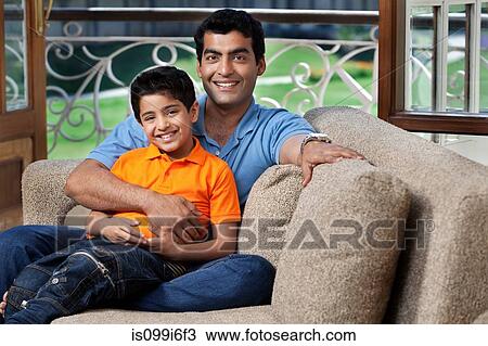 Stock Image - Portrait of father and son on a sofa. Fotosearch
