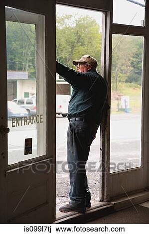 Senior man in doorway of store, looking out View Large Photo Image Stock Image - Senior man in doorway of store, looking out. Fotosearch