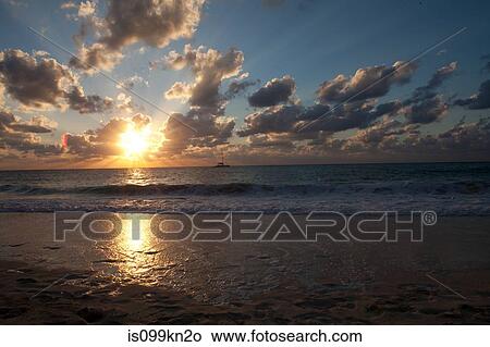 Sunset and sea washing over beach, Grand Cayman, Cayman Islands View Large Photo Image Picture - Sunset and sea washing over beach, Grand Cayman, Cayman Islands. Fotosearch