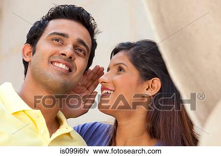 Stock Photo - Woman whispering in a mans ear. Fotosearch