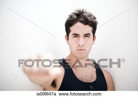 Young man holding fist out towards camera, focus on background View Large Photo Image Stock Image - Young man holding fist out towards camera, focus on background. Fotosearch