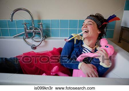 Young woman in bath, wearing costume and blowing party blower View Large Photo Image Stock Photography - Young woman in bath, wearing costume and blowing party blower. Fotosearch