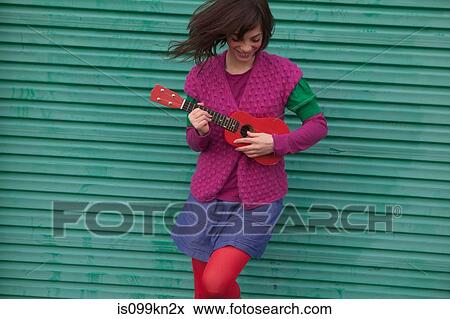 Stock Photo - Young woman playing ukulele. Fotosearch