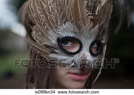 Young woman wearing a mask of feathers View Large Photo Image Picture - Young woman wearing a mask of feathers. Fotosearch