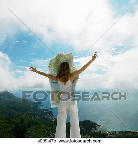 Picture - Young woman with map blowing over her face. Fotosearch