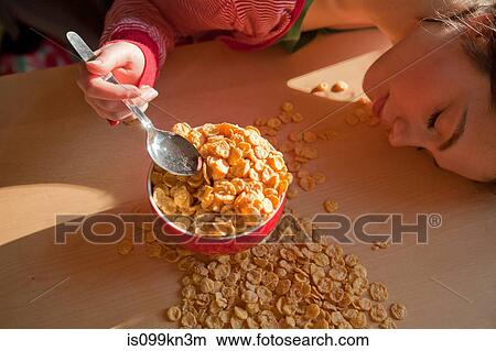 Picture - Young woman with spilt breakfast cereal. Fotosearch