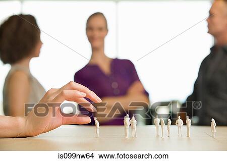 Architect's hand touching model figures on desk View Large Photo Image Picture - Architect's hand touching model figures on desk. Fotosearch