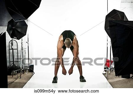 Athlete at photo shoot, stretching View Large Photo Image Stock Photo - Athlete at photo shoot, stretching. Fotosearch
