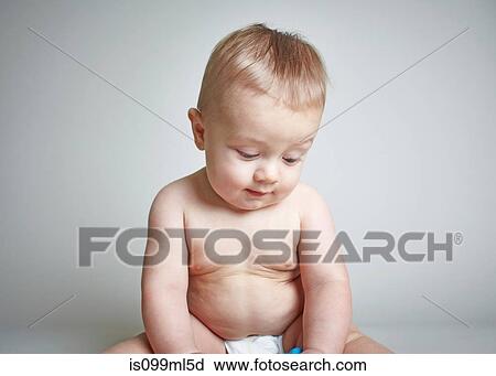 Stock Image - Baby boy looking down. Fotosearch