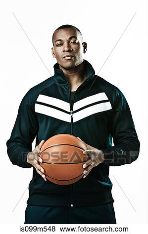 Stock Photo - Basketball player holding ball, portrait. Fotosearch
