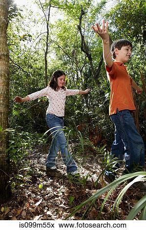 Boy and girl walking through forest View Large Photo Image Stock Photo - Boy and girl walking through forest. Fotosearch