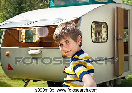 Stock Photography - Boy outside caravan, portrait. Fotosearch