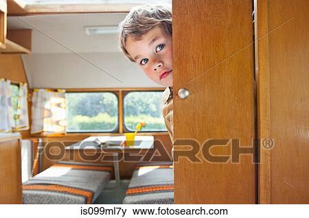 Boy peeking round door in caravan View Large Photo Image Stock Photo - Boy peeking round door in caravan. Fotosearch