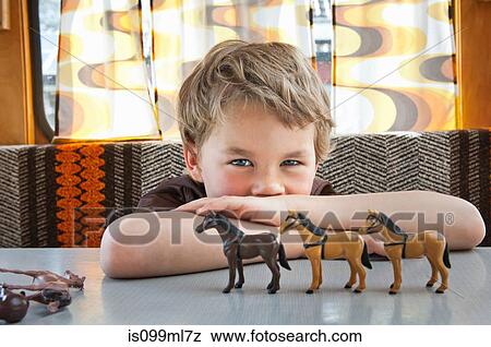 Boy playing with toy plastic horse in caravan View Large Photo Image Stock Photo - Boy playing with toy plastic horse in caravan. Fotosearch