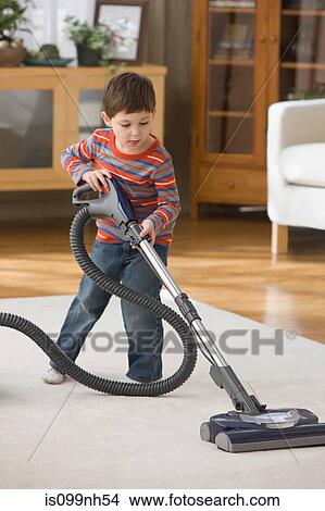 Boy using vacuum cleaner on rug View Large Photo Image Picture - Boy using vacuum cleaner on rug. Fotosearch