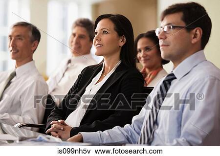Business colleagues sitting in office meeting View Large Photo Image Stock Photo - Business colleagues sitting in office meeting. Fotosearch