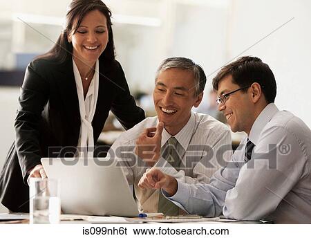 Business colleagues using laptop in office View Large Photo Image Stock Photograph - Business colleagues using laptop in office. Fotosearch