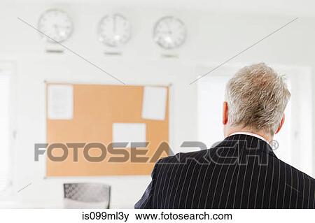 Stock Photo - Businessman in office, rear view. Fotosearch
