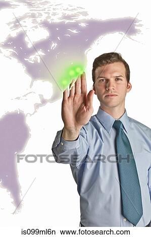 Picture - Businessman interacting with holographic map. Fotosearch