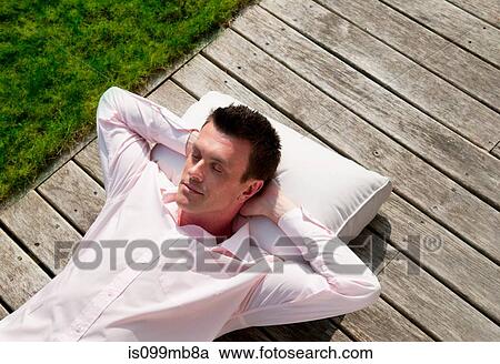 Businessman lying on decking sleeping View Large Photo Image Stock Image - Businessman lying on decking sleeping. Fotosearch