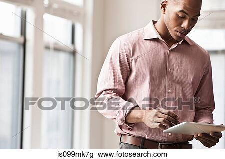 Stock Image - Businessman using digital tablet. Fotosearch