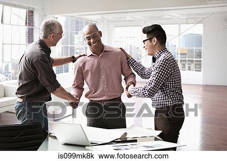 Businessmen congratulating colleague View Large Photo Image Stock Image - Businessmen congratulating colleague. Fotosearch