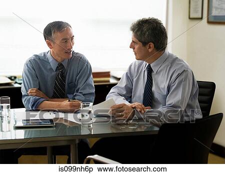Businessmen discussing report in office View Large Photo Image Stock Photography - Businessmen discussing report in office. Fotosearch