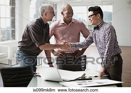 Businessmen shaking hands in office View Large Photo Image Picture - Businessmen shaking hands in office. Fotosearch