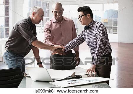 Businessmen shaking hands in office View Large Photo Image Stock Image - Businessmen shaking hands in office. Fotosearch