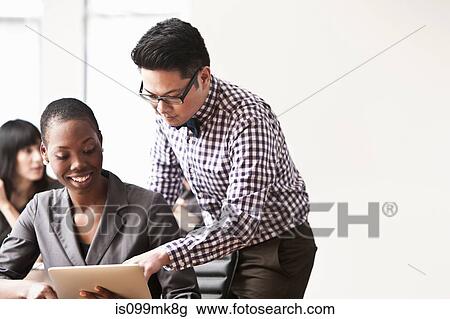 Stock Image - Businesspeople using digital tablet. Fotosearch