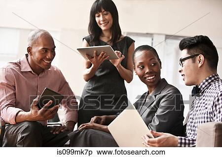 Stock Photography - Businesspeople using digital tablets and handheld computers. Fotosearch