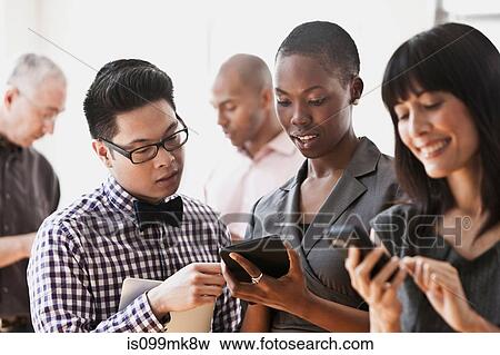 Businesspeople using handheld computers and digital tablets View Large Photo Image Stock Photo - Businesspeople using handheld computers and digital tablets. Fotosearch