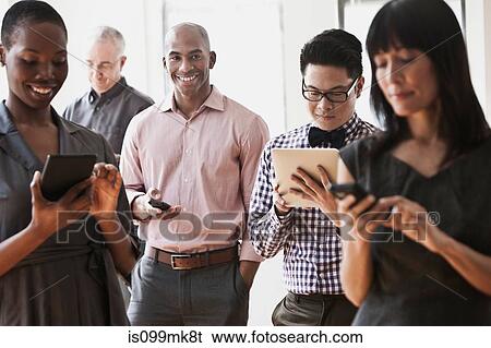 Businesspeople using handheld computers and digital tablets View Large Photo Image Stock Photograph - Businesspeople using handheld computers and digital tablets. Fotosearch