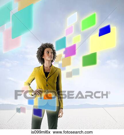 Businesswoman looking at holographic screens in desert View Large Photo Image Stock Photo - Businesswoman looking at holographic screens in desert. Fotosearch