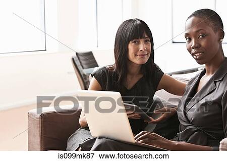 Businesswomen using laptop, portrait View Large Photo Image Stock Photo - Businesswomen using laptop, portrait. Fotosearch