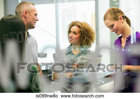 Colleagues in discussion in office View Large Photo Image Picture - Colleagues in discussion in office. Fotosearch