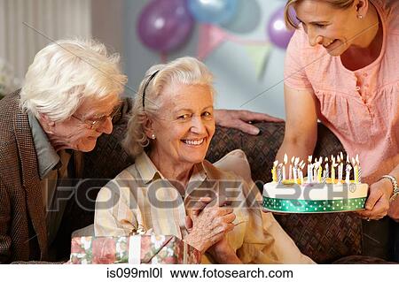 Daughter giving birthday cake to senior mother View Large Photo Image Stock Image - Daughter giving birthday cake to senior mother. Fotosearch
