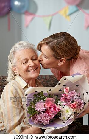 Daughter giving senior mother bouquet of flowers View Large Photo Image Stock Photo - Daughter giving senior mother bouquet of flowers. Fotosearch