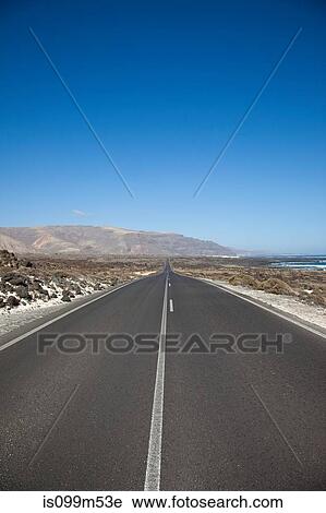 Stock Image - Diminishing perspective of road in Lanzarote, Canary Islands. Fotosearch