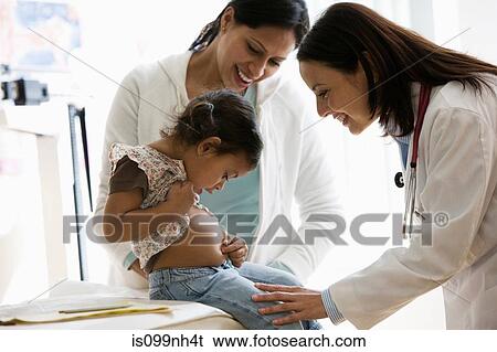 Doctor examing young girl in office View Large Photo Image Stock Photograph - Doctor examing young girl in office. Fotosearch