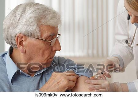Doctor giving senior man injection View Large Photo Image Stock Photo - Doctor giving senior man injection. Fotosearch