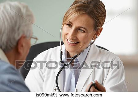 Doctor taking senior mans blood pressure, close up View Large Photo Image Stock Photograph - Doctor taking senior mans blood pressure, close up. Fotosearch