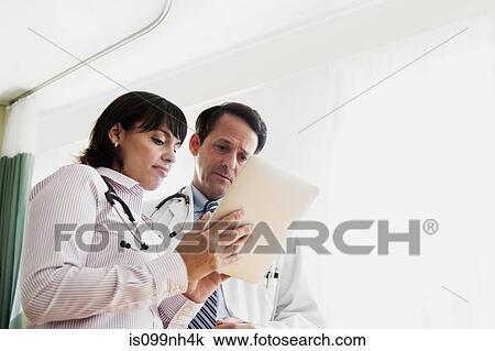 Doctors in discussion over patients records in hospital View Large Photo Image Stock Image - Doctors in discussion over patients records in hospital. Fotosearch