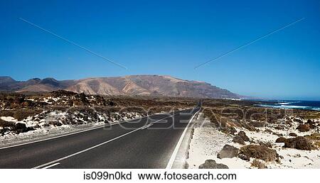 Stock Image - Empty road through Lanzarote, Canary Islands, Spain. Fotosearch