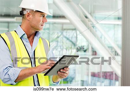 Engineer using digital tablet in office View Large Photo Image Stock Image - Engineer using digital tablet in office. Fotosearch